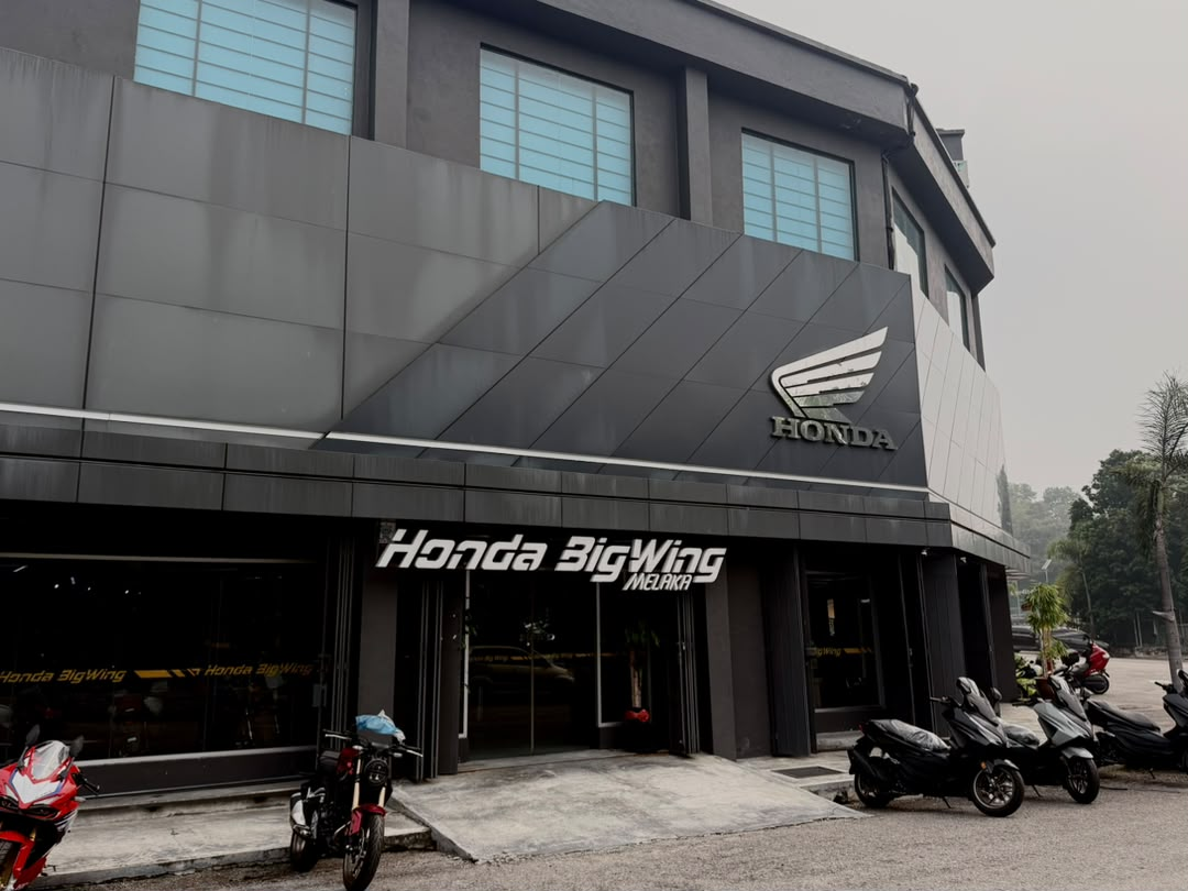 Pandangan luaran showroom Honda BigWing Melaka dengan logo Honda di atas dan papan tanda 'Honda BigWing MELAKA' di pintu masuk