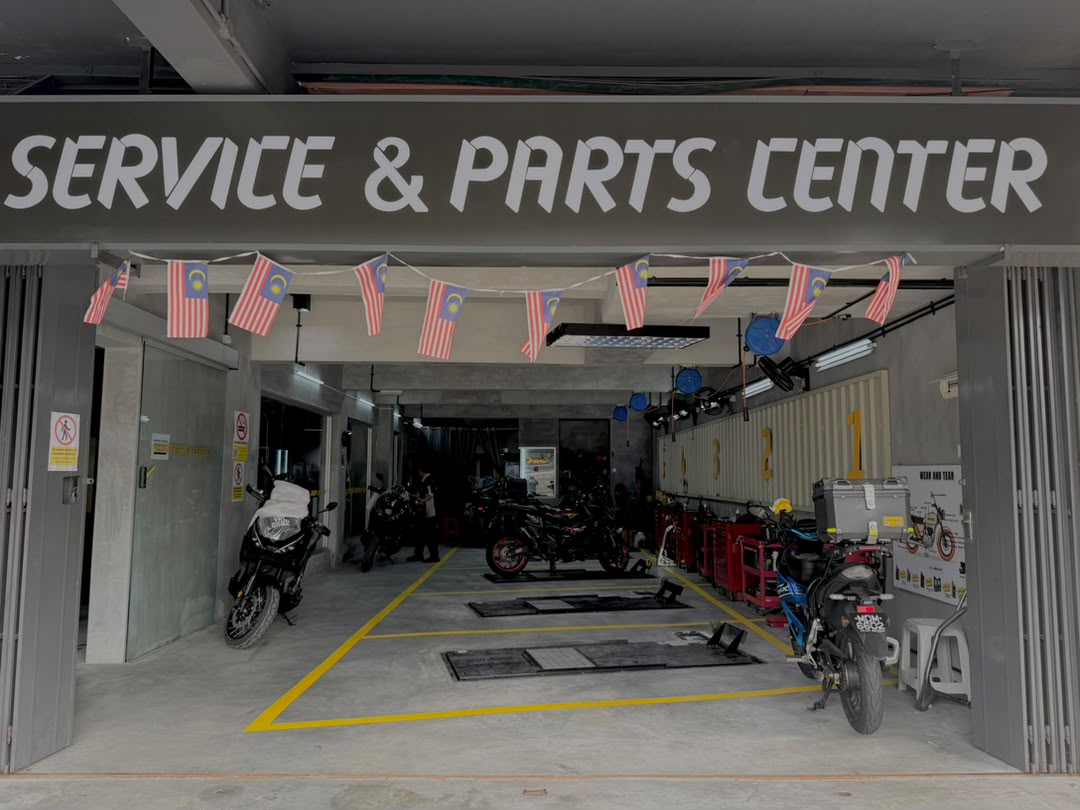 Pintu masuk Service & Parts Center Honda BigWing dengan papan tanda 'SERVICE & PARTS CENTER' dan teluk servis motosikal